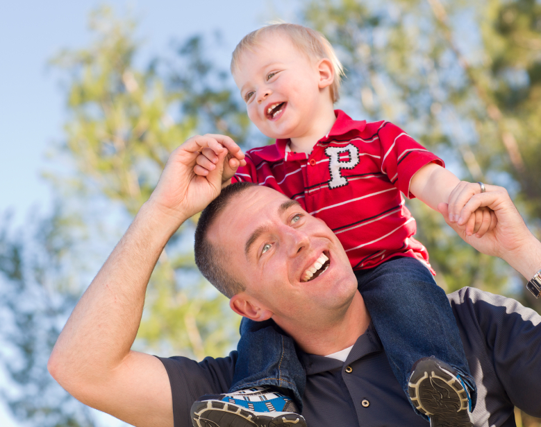 Young Laughing Father and Child  Having Piggy Back Fun.