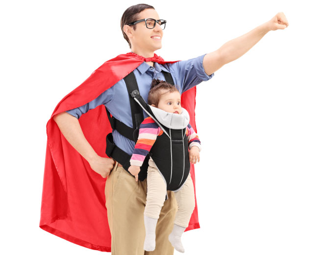 Male superhero with raised fist carrying a baby