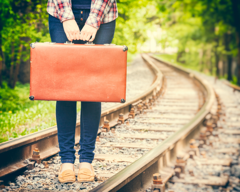 girl with retro suitcase on railway