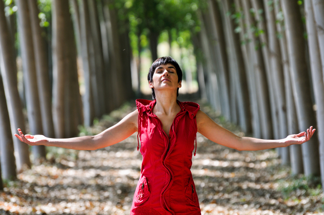 Woman dressed in red, meditating in the forest