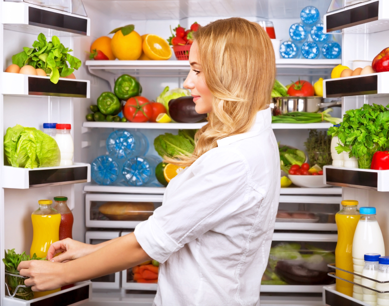 Happy female search something in the fridge