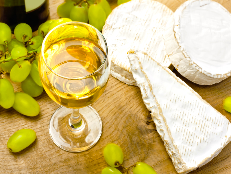 White wine, brie, caembert and grape on the wood surface