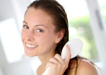 Portrait of smiling girl brushing her hair