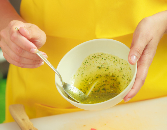 Woman preparing fresh salad dressing